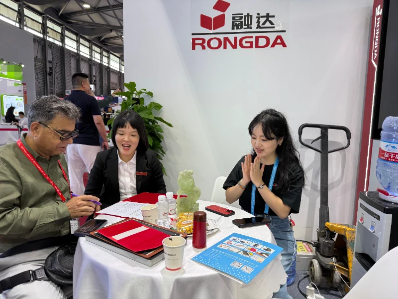 Group photo of Rongda staff and overseas clients in front of Rongda machine at All in Print China 2026
